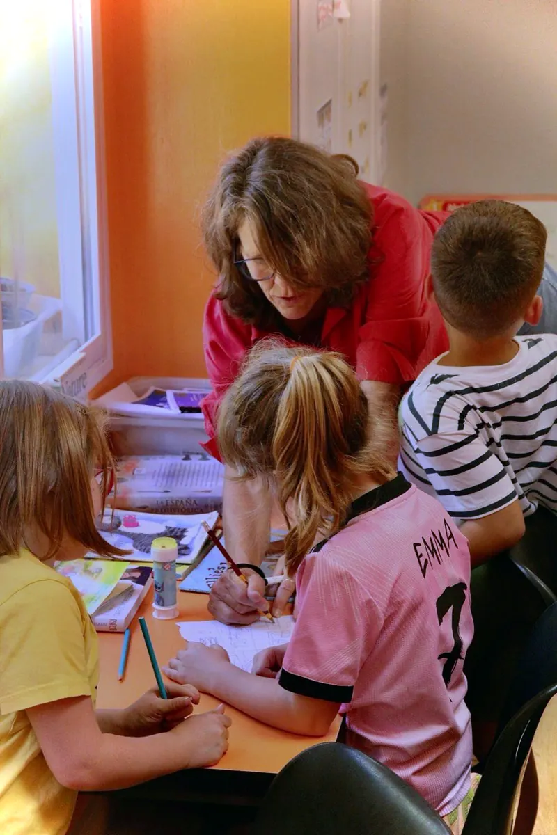 Profesora de inglés con niños pequeños en la academia